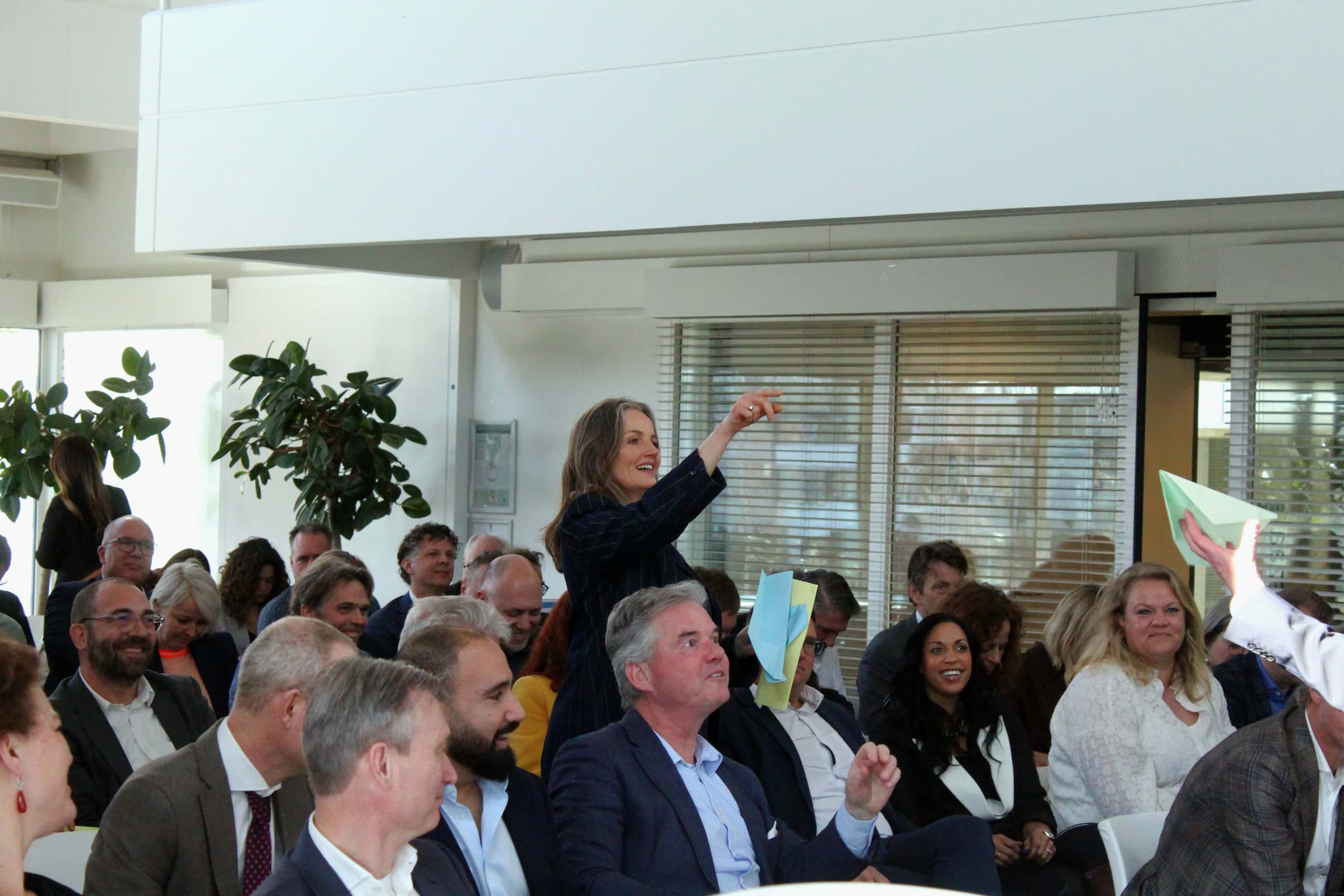 Op deze foto zie je een zaal vol mensen die aanwezig zijn bij de officële opening.