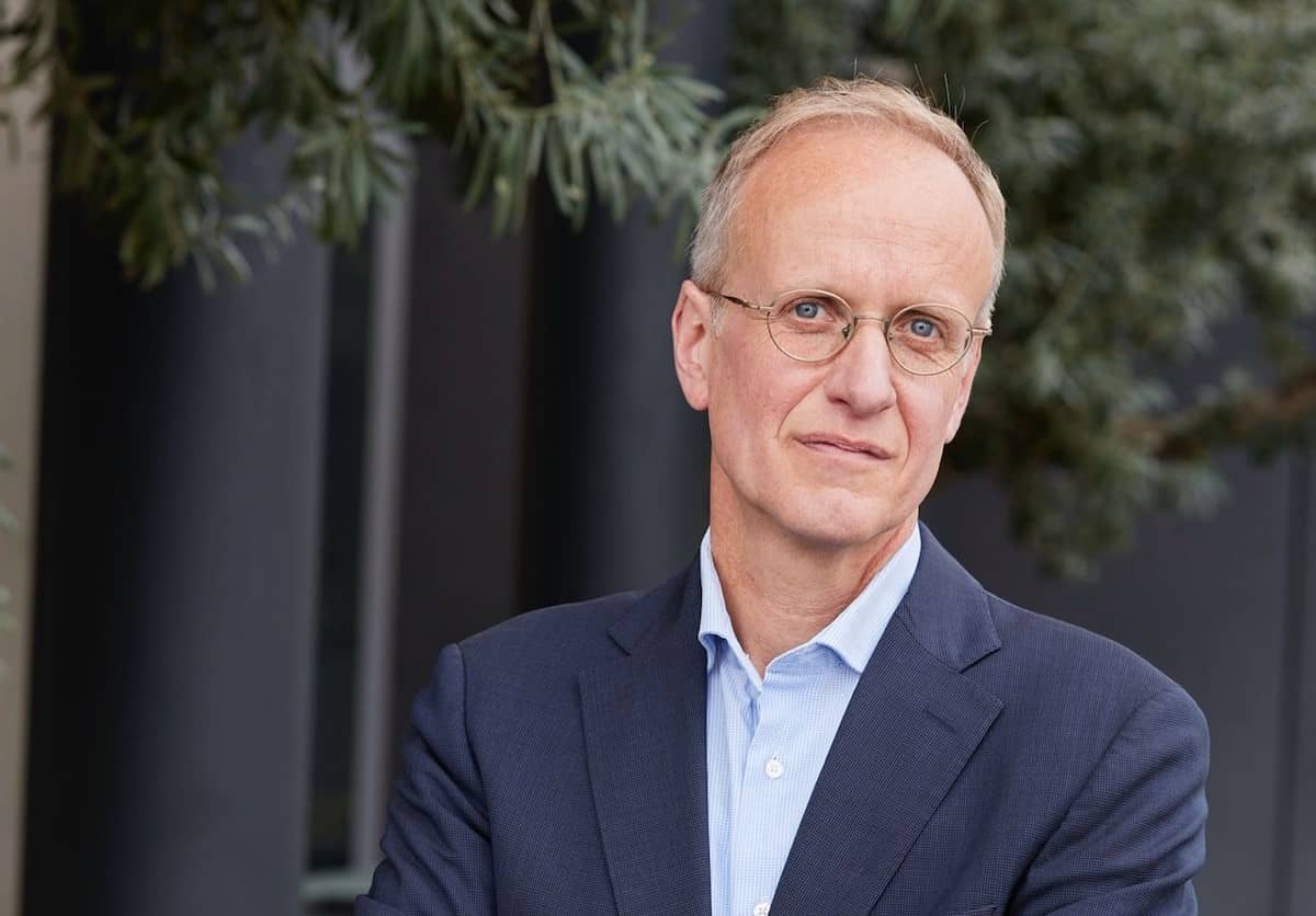 Portret van een man met wat grijzig haar en bril, de achtergrond is wazig