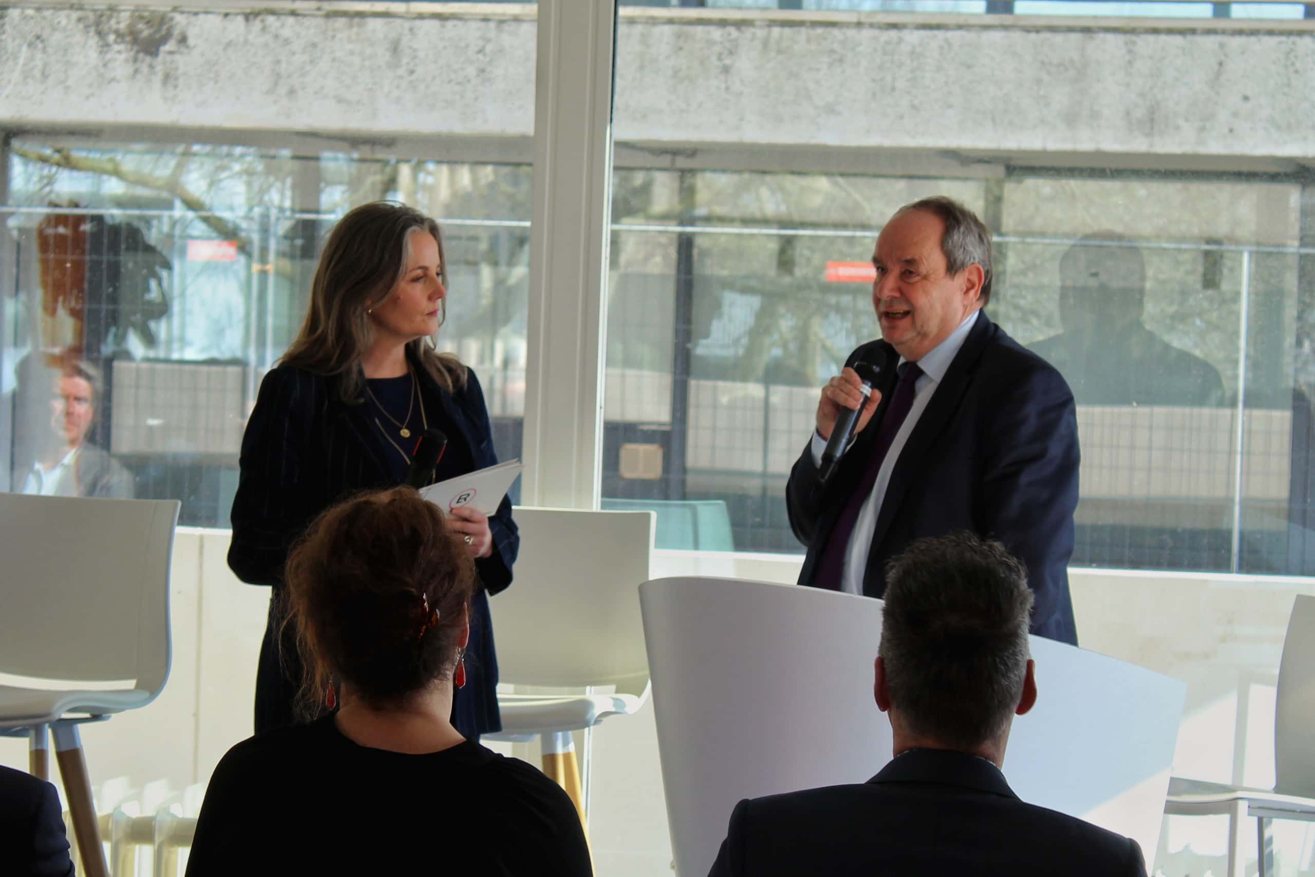 Op deze foto zie je gespreksleider Esther van Rijswijk voor de zaal in gesprek met minister Vijlbrief.